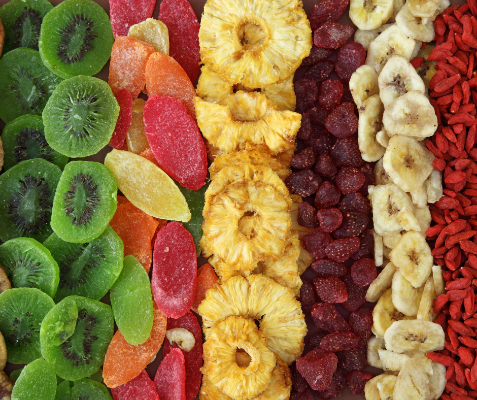 Snacking on dried fruits including kiwi, pineapple, banana chips, berries, and goji berries arranged in rows